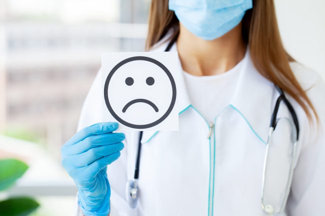 doctor-holding-a-cards-with-symbol-sad-smile-2023-11-27-04-58-21-utc-min