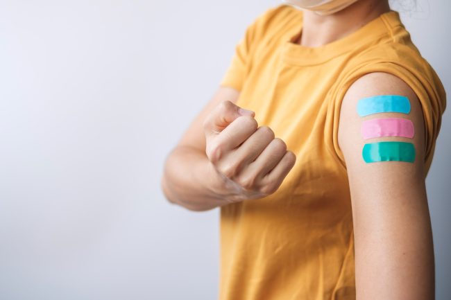 woman-showing-bandage-after-receiving-covid-19-vac-2023-11-27-05-04-56-utc-min