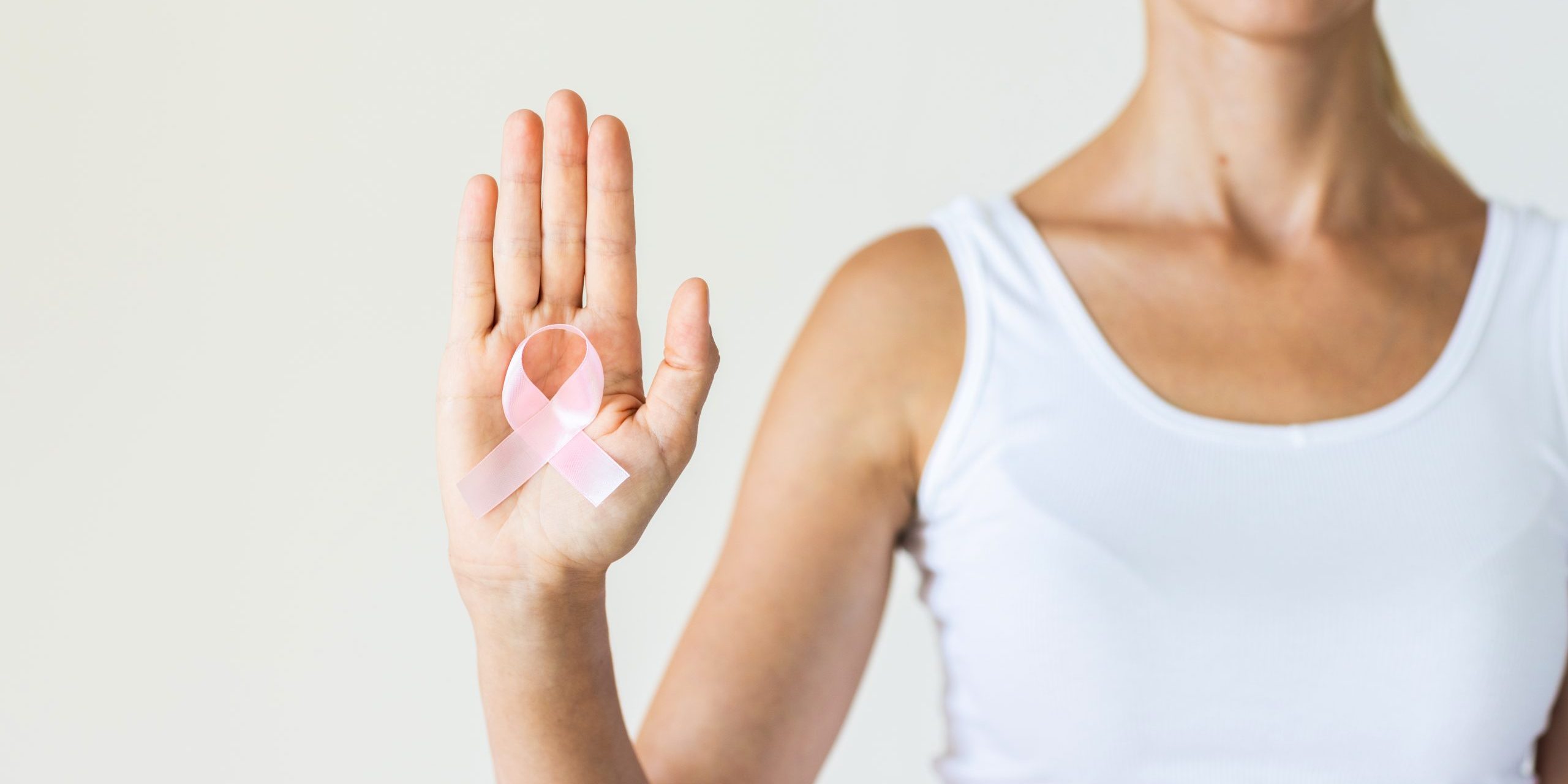 Woman with pink ribbon symbol of breast cancer awareness month.