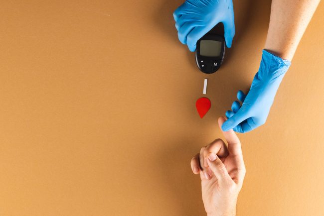 hands-of-gloved-doctor-with-glucometer-taking-bloo-2023-11-27-05-33-15-utc-min